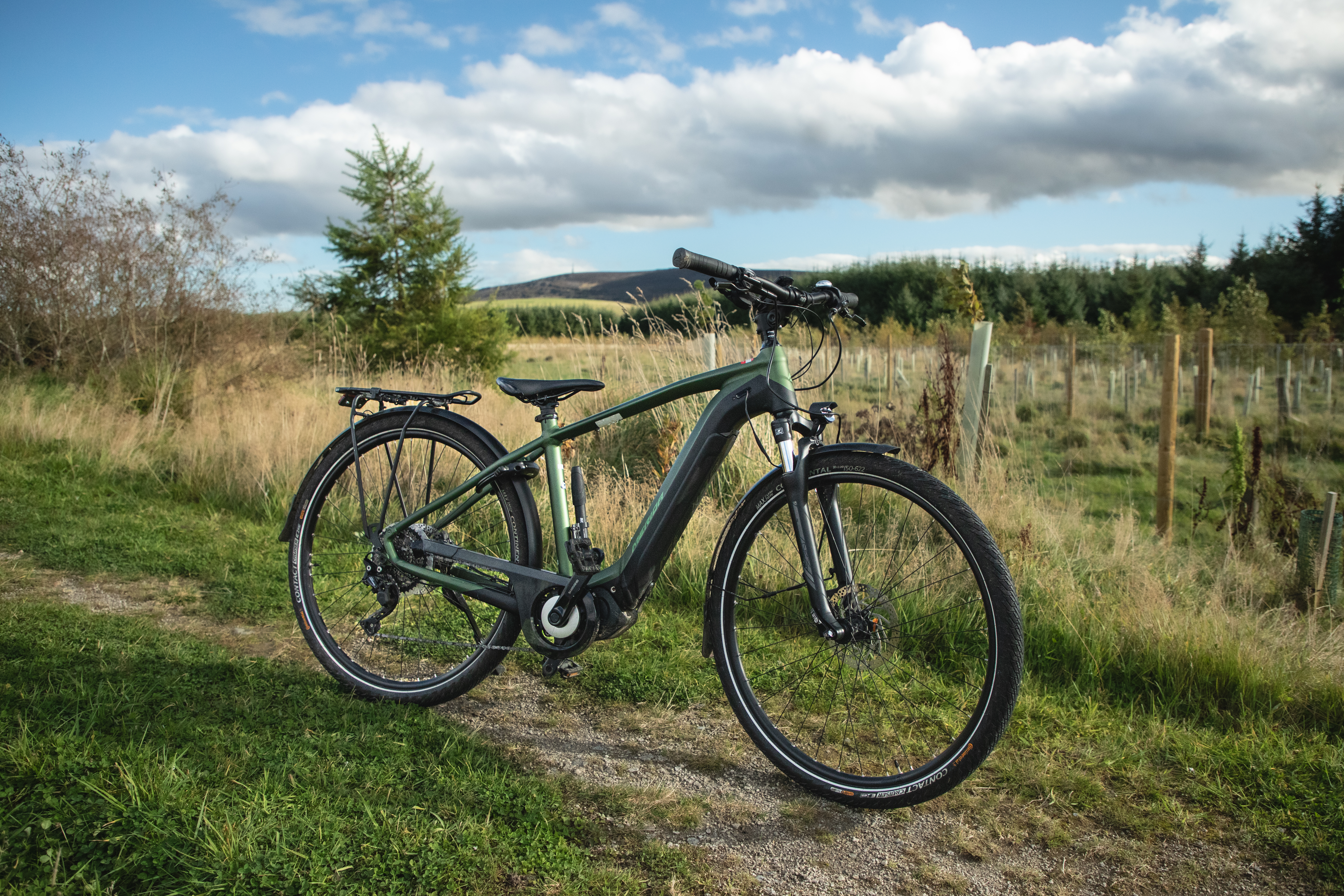 Two cyclists riding along a forest path